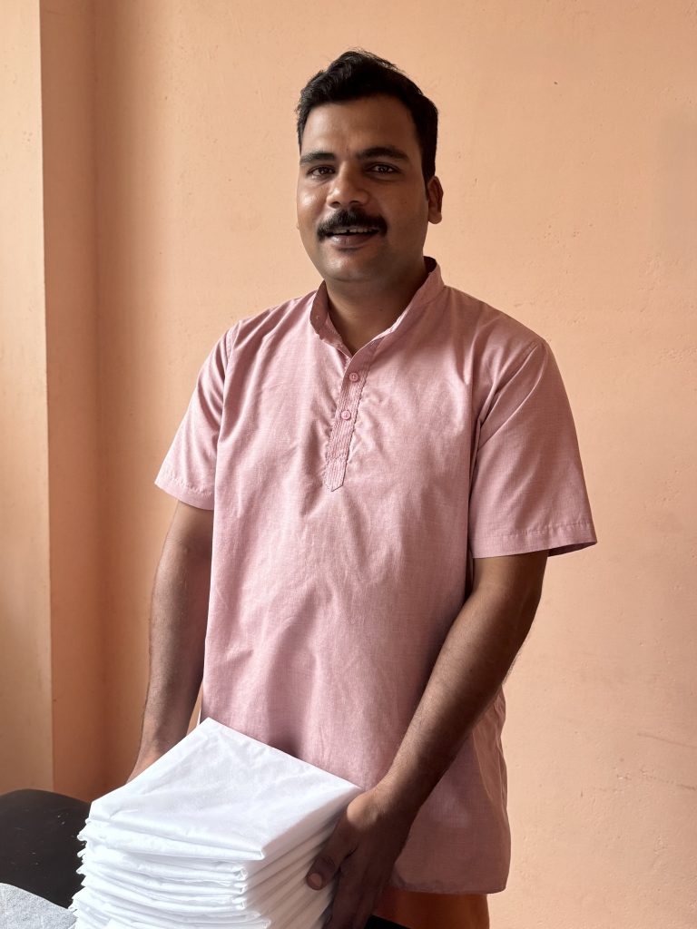 Jerin - male therapist at Prakruthi Ayurveda, Cherai Beach, preparing covers for the massage table